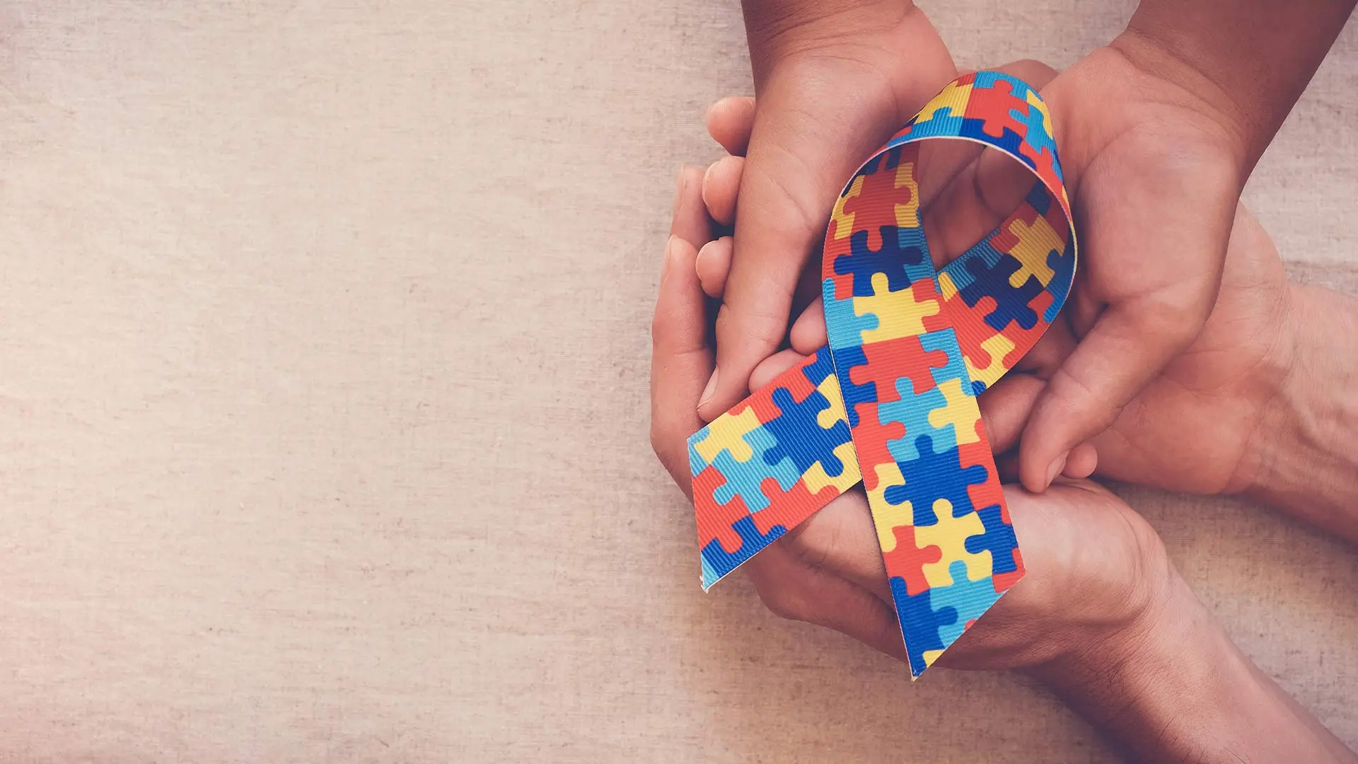 Photo off hands holding autism awareness puzzle in San Diego, CA.