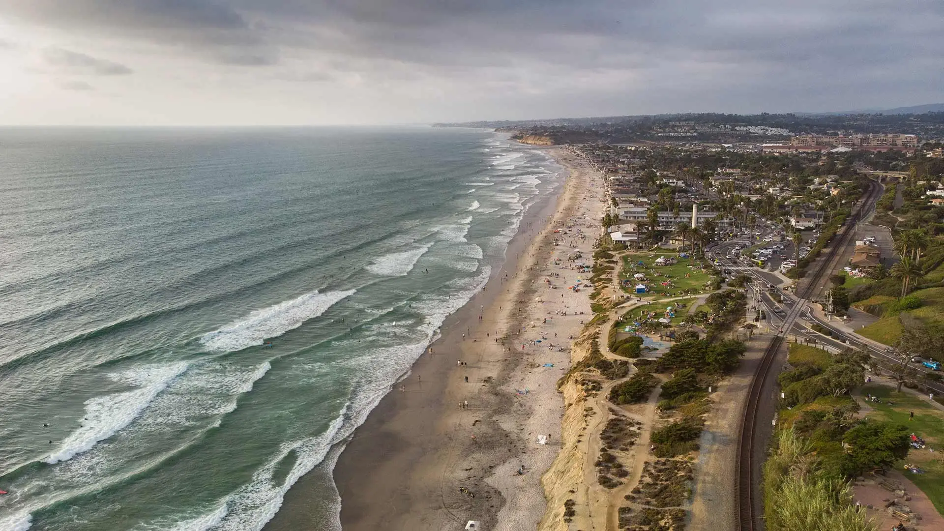 Aerial photo of the Del Mar, California coastline with waves rolling in.